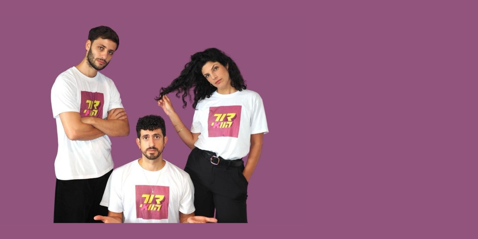 שלושה צעירים בלבוש אחיד – חולצות לבנות עם הדפס גרפי בולט – על רקע סגול אחיד, כשהם עומדים/יושבים בפוזות שונות שמשדרות הומור, קלילות ונוכחות בימתית. הקומפוזיציה הפשוטה והישירה מדגישה את הדינמיקה בין הדמויות ואת האופי העכשווי והקבוצתי של הדימוי.